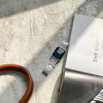 White and gray shell pattern resin strap for Apple Watch on a wrist.