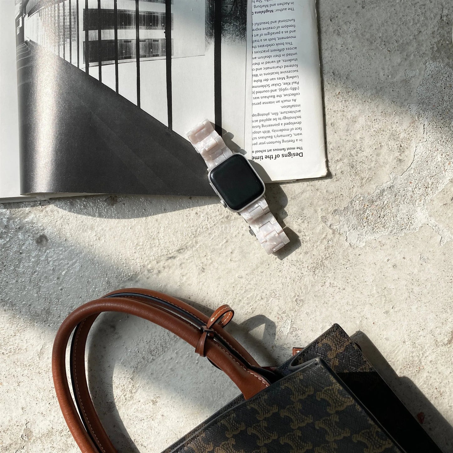 White and gray shell pattern resin strap for Apple Watch on a wrist.