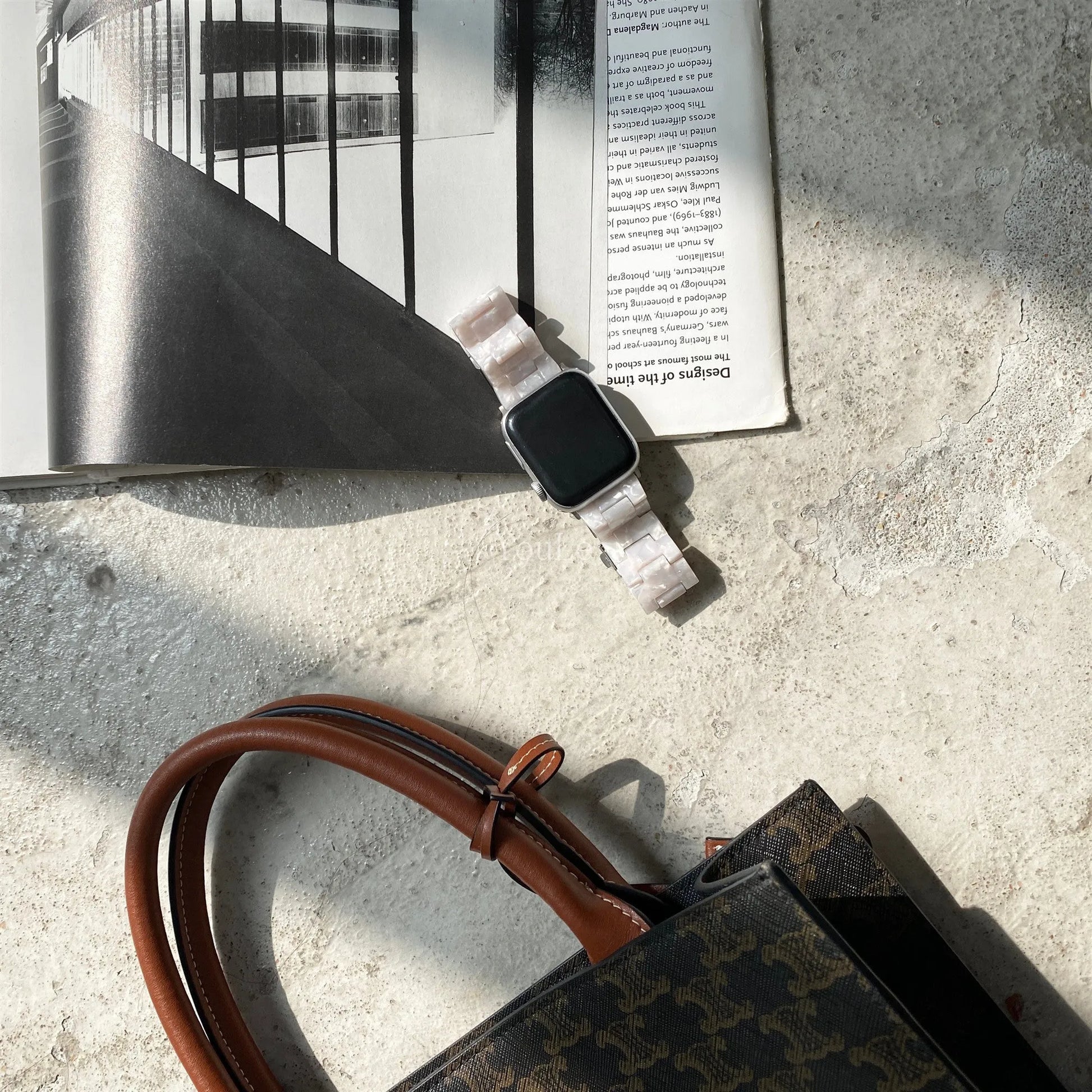 White and gray shell pattern resin strap for Apple Watch on a wrist.