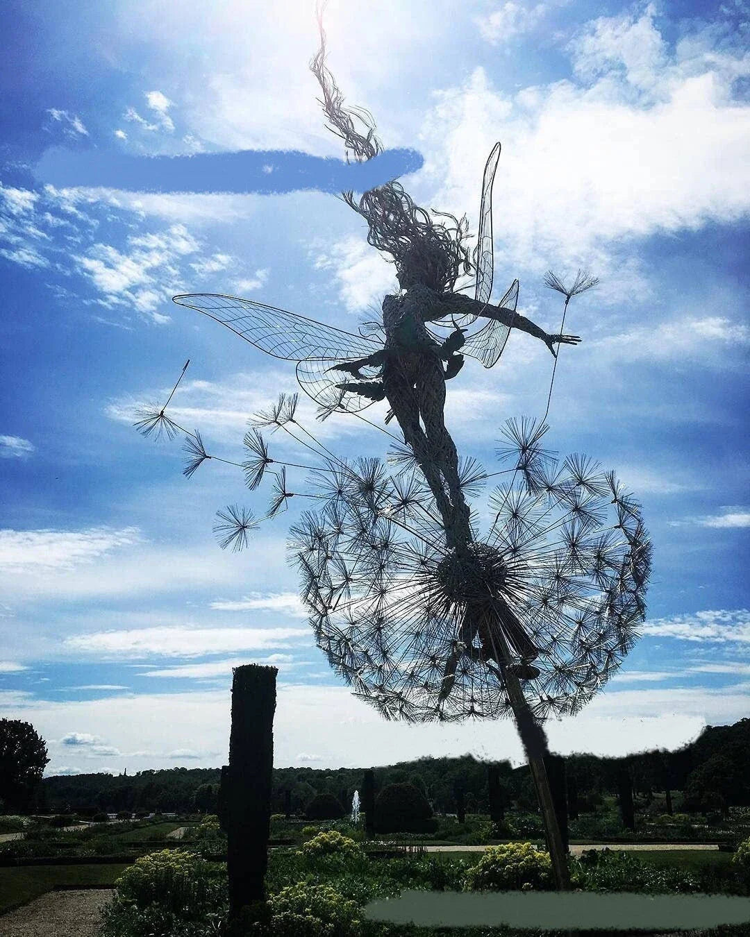 Enchanting metal fairy garden sculptures in the shape of fairies and pixies dancing on dandelions, designed for year-round outdoor or indoor display