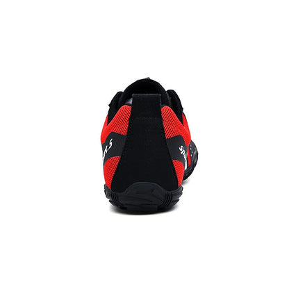 Casual red outdoor wading shoes with mesh upper and textured rubber sole on a sandy beach.
