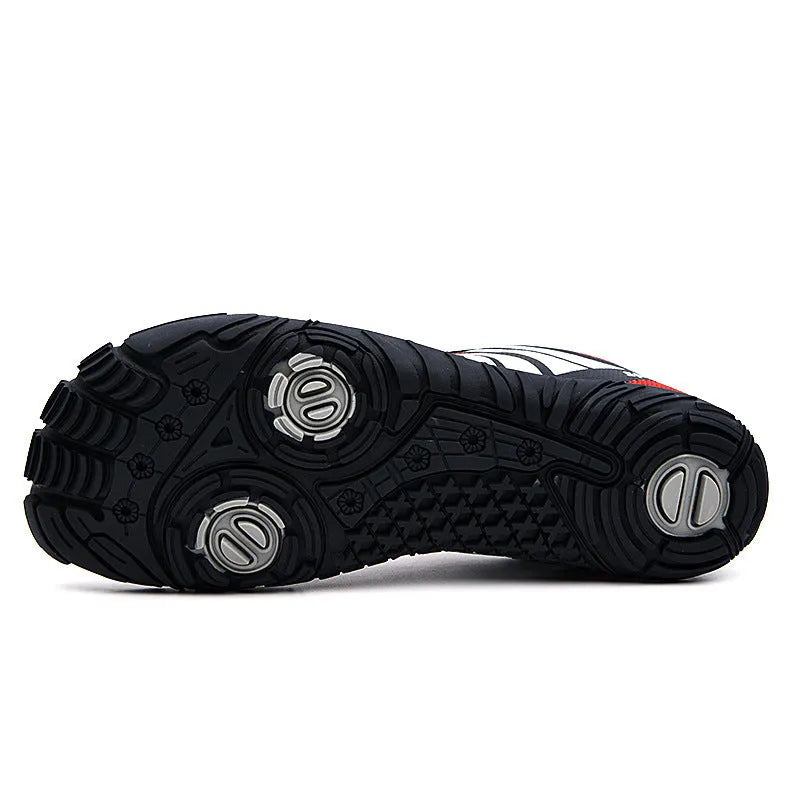 Casual red outdoor wading shoes with mesh upper and textured rubber sole on a sandy beach.