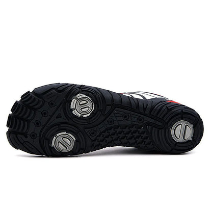 Casual red outdoor wading shoes with mesh upper and textured rubber sole on a sandy beach.