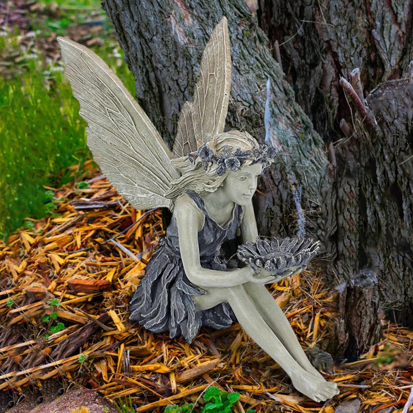 A charming resin fairy statue holding a sunflower bowl, with a flower crown and petal-inspired skirt, designed for outdoor garden decor