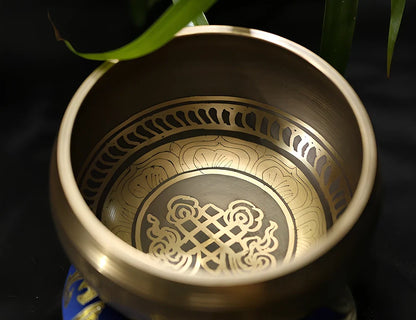 Copper meditation singing bowl with auspicious knot pattern and leather striker