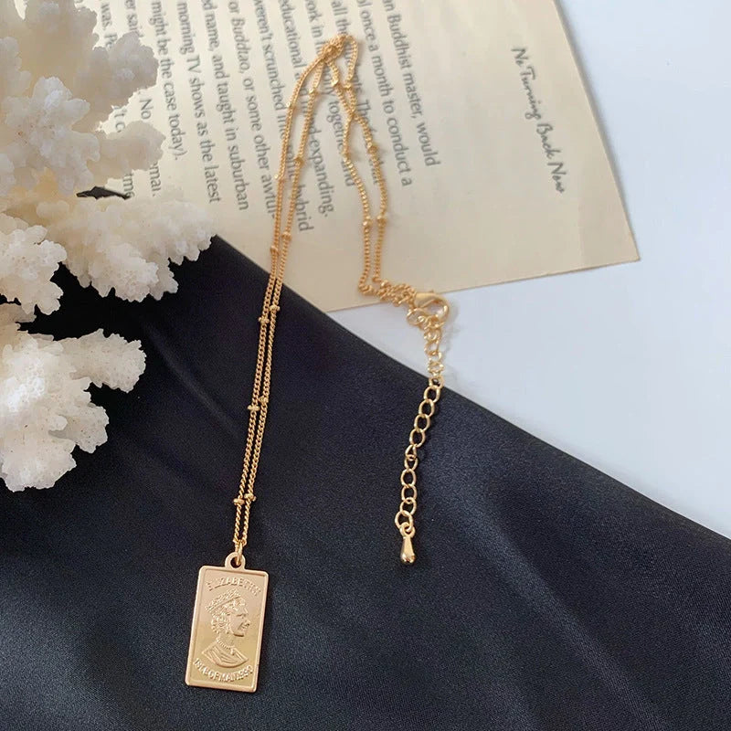 Gold alloy abstract face choker necklace with geometric pendant