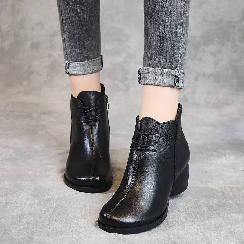 Women's brown leather retro Martin boots with a thick block heel and round toe on a wooden floor.