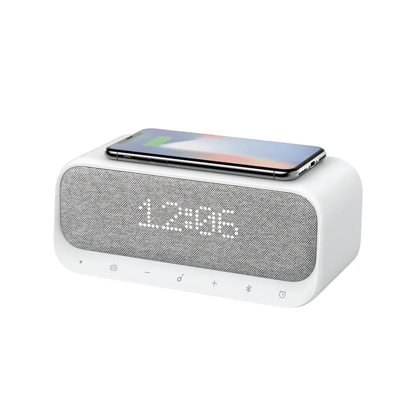 White Anker Soundcore all-in-one Bluetooth speaker with wireless charging pad and alarm clock display.