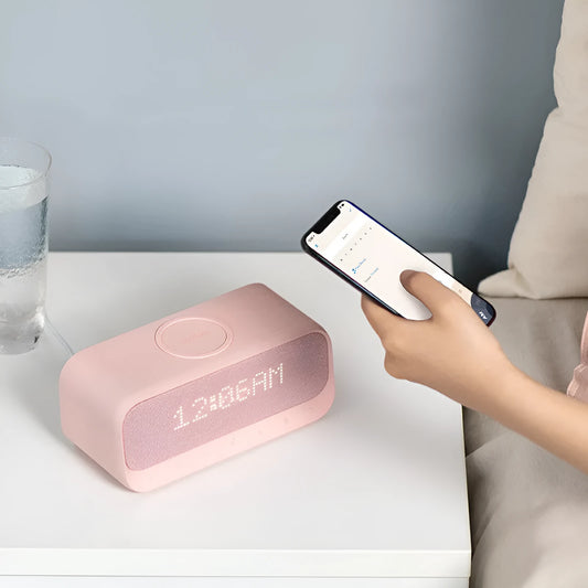 White Anker Soundcore all-in-one Bluetooth speaker with wireless charging pad and alarm clock display.