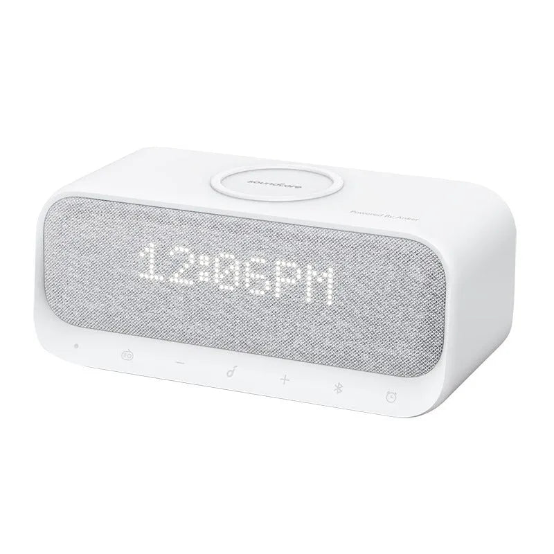 White Anker Soundcore all-in-one Bluetooth speaker with wireless charging pad and alarm clock display.