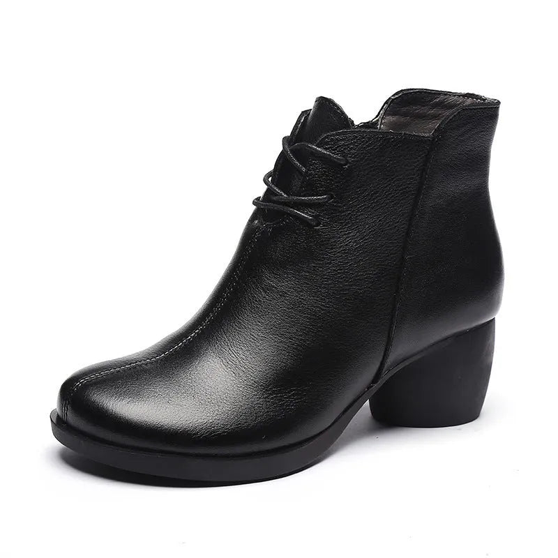 Women's brown leather retro Martin boots with a thick block heel and round toe on a wooden floor.
