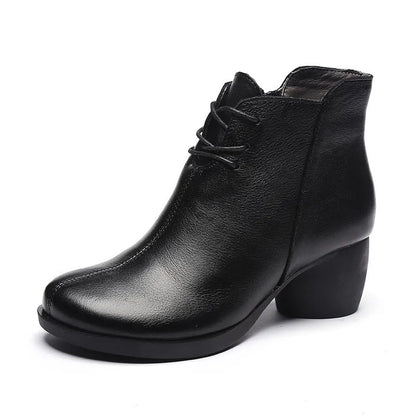 Women's brown leather retro Martin boots with a thick block heel and round toe on a wooden floor.