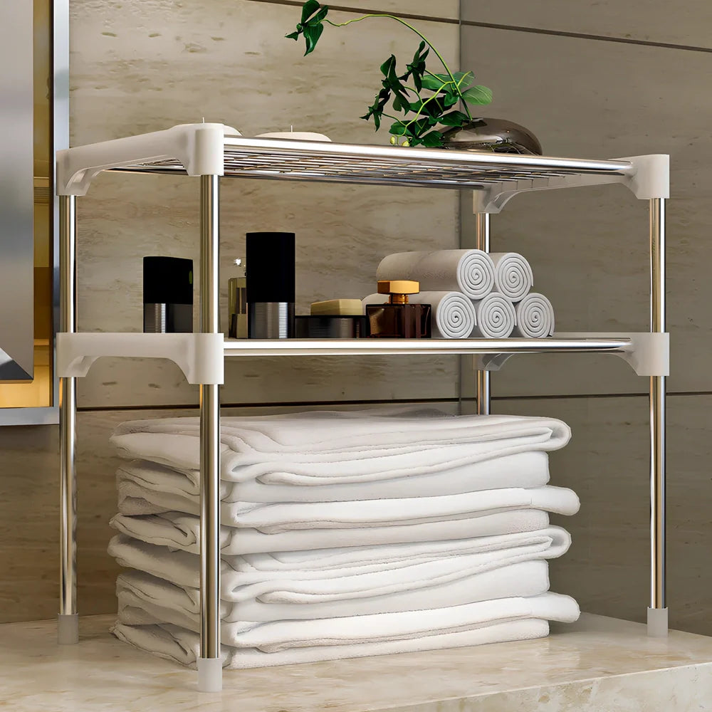 Silver and white microwave shelf rack with iron tubes and plastic connectors measuring 56.9cm wide