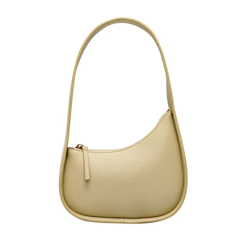Structured caramel half-moon leather women's shoulder bag with a wide adjustable strap and zip closure.