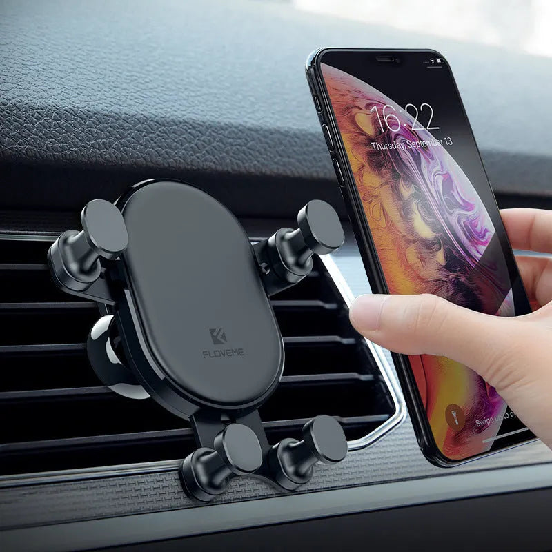 Black car vent phone holder with gravity lock mechanism, shown holding a smartphone at an angle.