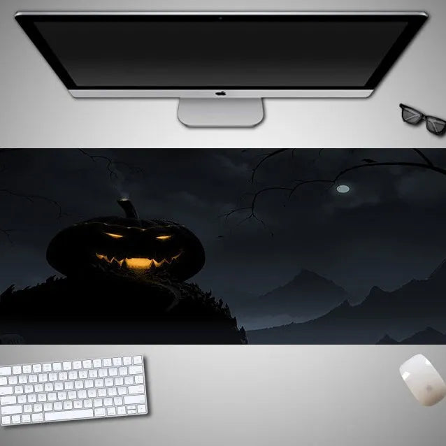 Oversized black Halloween-themed mouse pad with graphic design on a desk with keyboard and mouse