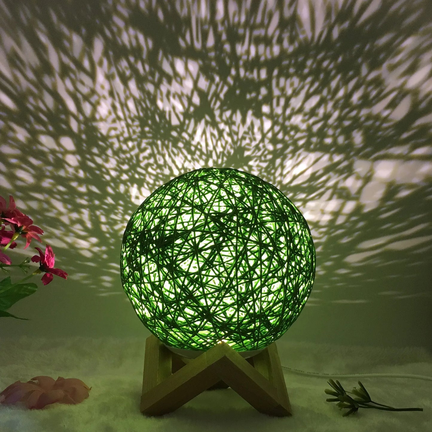Spherical hand-knitted rattan table lamp with remote control on a wooden desk