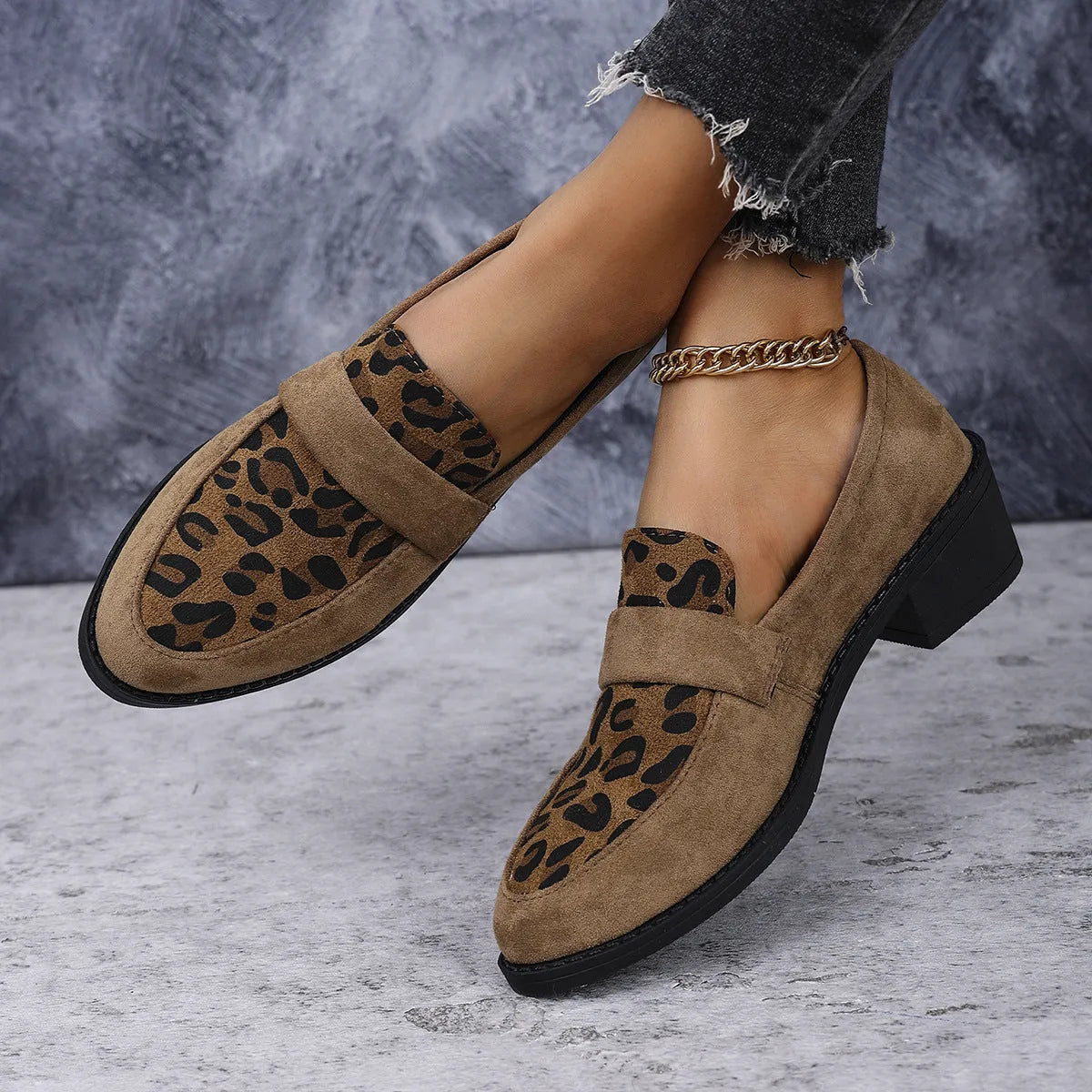 Leopard print slip-on suede pump shoe with chunky mid heel and pointed toe on a rubber sole.
