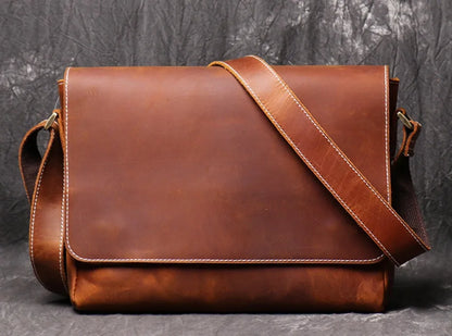 Vintage brown leather mens messenger bag with flap open, showing internal phone pouch and zipper pocket.