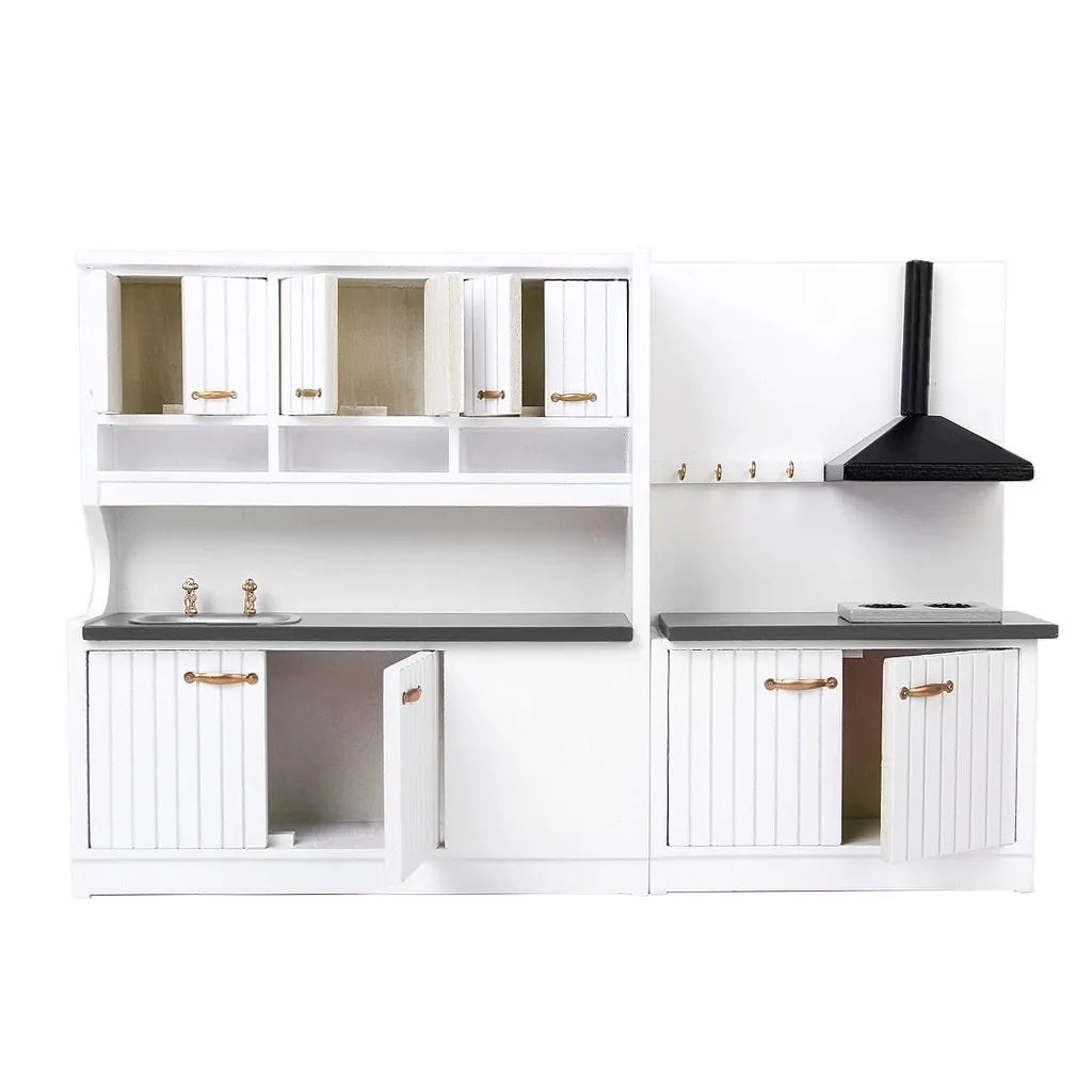 White two-piece dollhouse kitchen cabinet set with sink and stove units on a table.