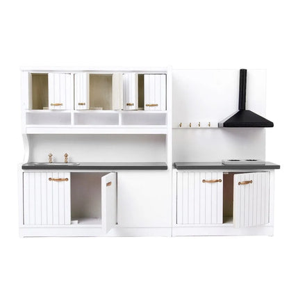 White two-piece dollhouse kitchen cabinet set with sink and stove units on a table.