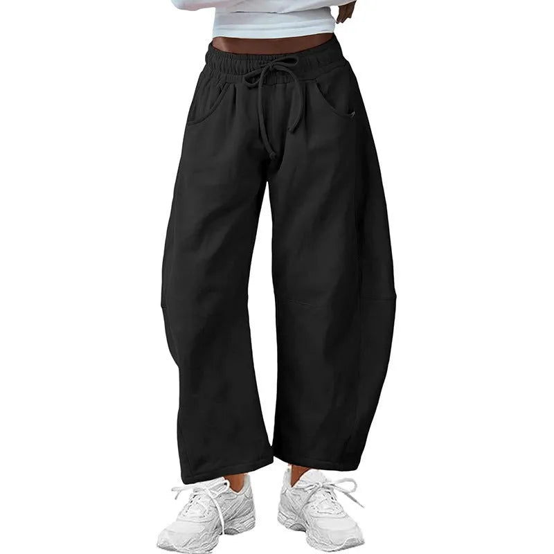 Loose fit cropped sweatpants in apricot colour with drawstring waist and side pockets on a neutral background.
