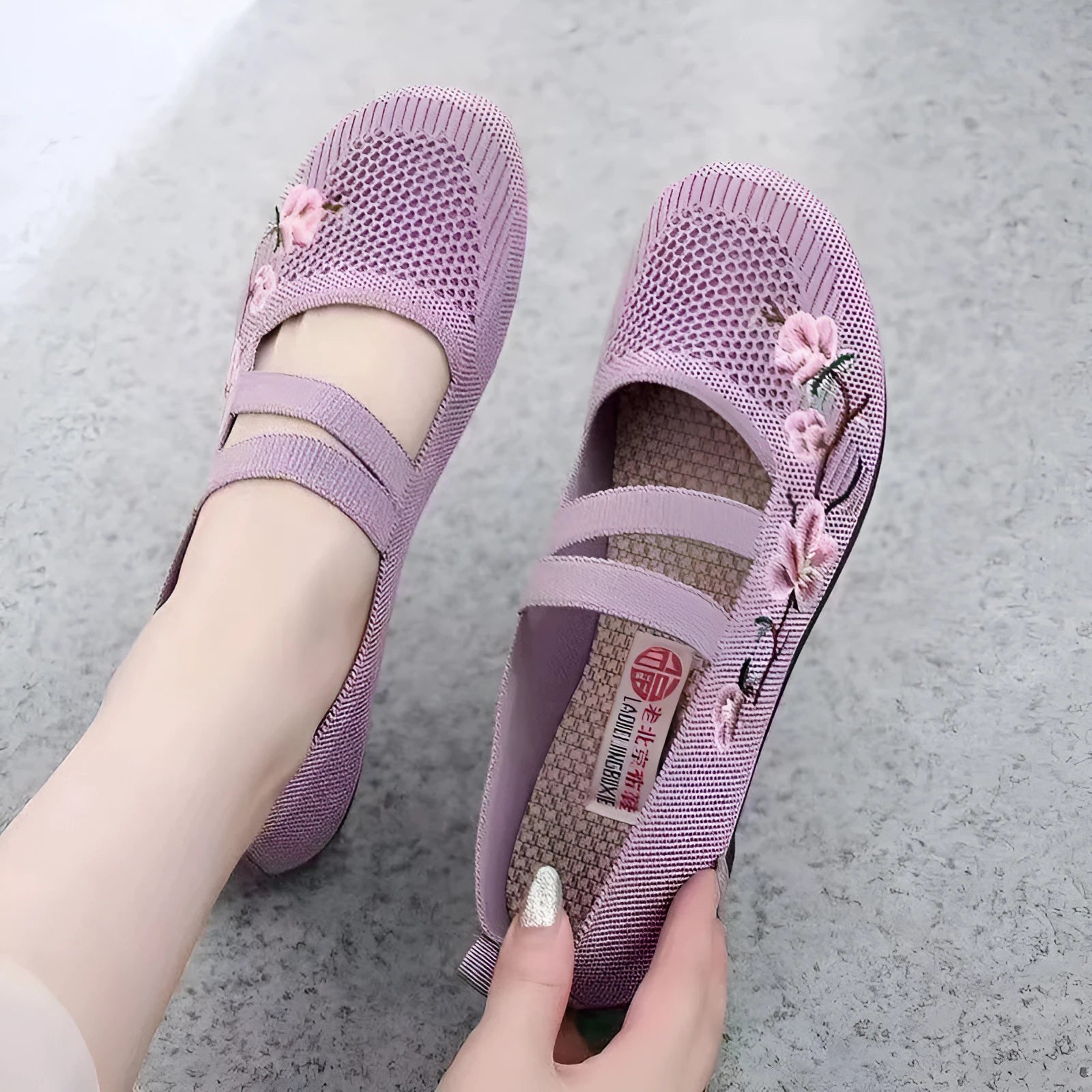 A pair of slip-on flat shoes with an elastic upper and rubber sole, shown in an embroidered colour option.