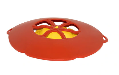 Green silicone spill stopper pan lid on cooking pot showing flexible edges and steam vent