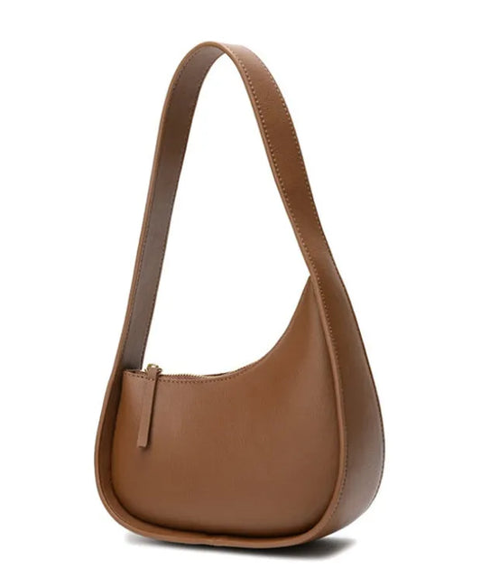Structured caramel half-moon leather women's shoulder bag with a wide adjustable strap and zip closure.