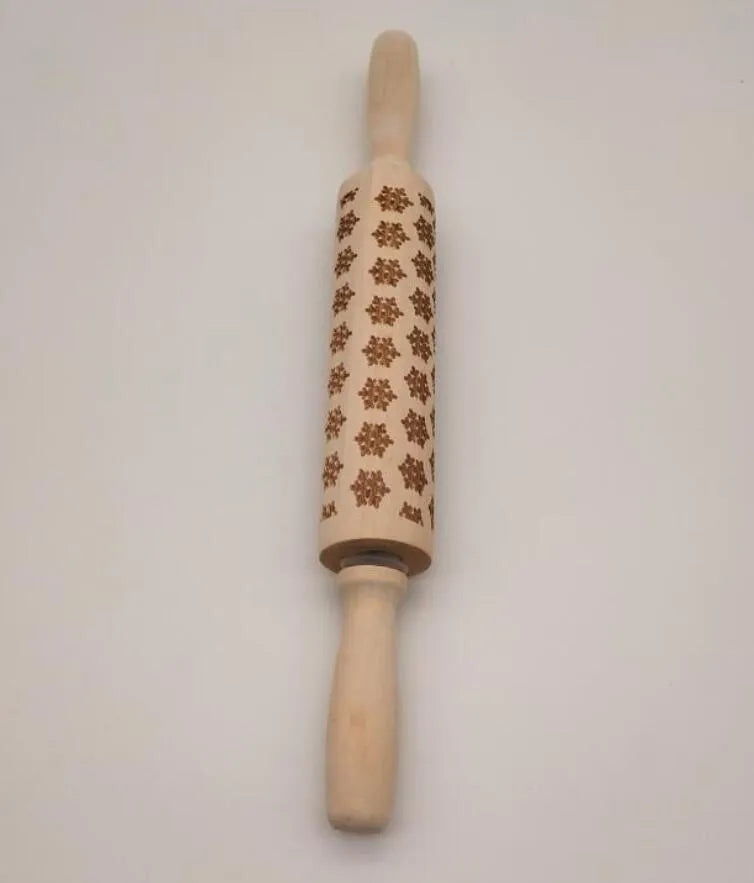 Wooden rolling pin with engraved Christmas patterns including reindeer and snowflakes on a 45cm long barrel.