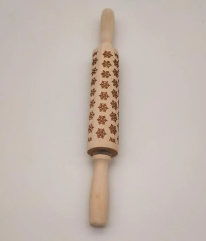 Wooden rolling pin with engraved Christmas patterns including reindeer and snowflakes on a 45cm long barrel.