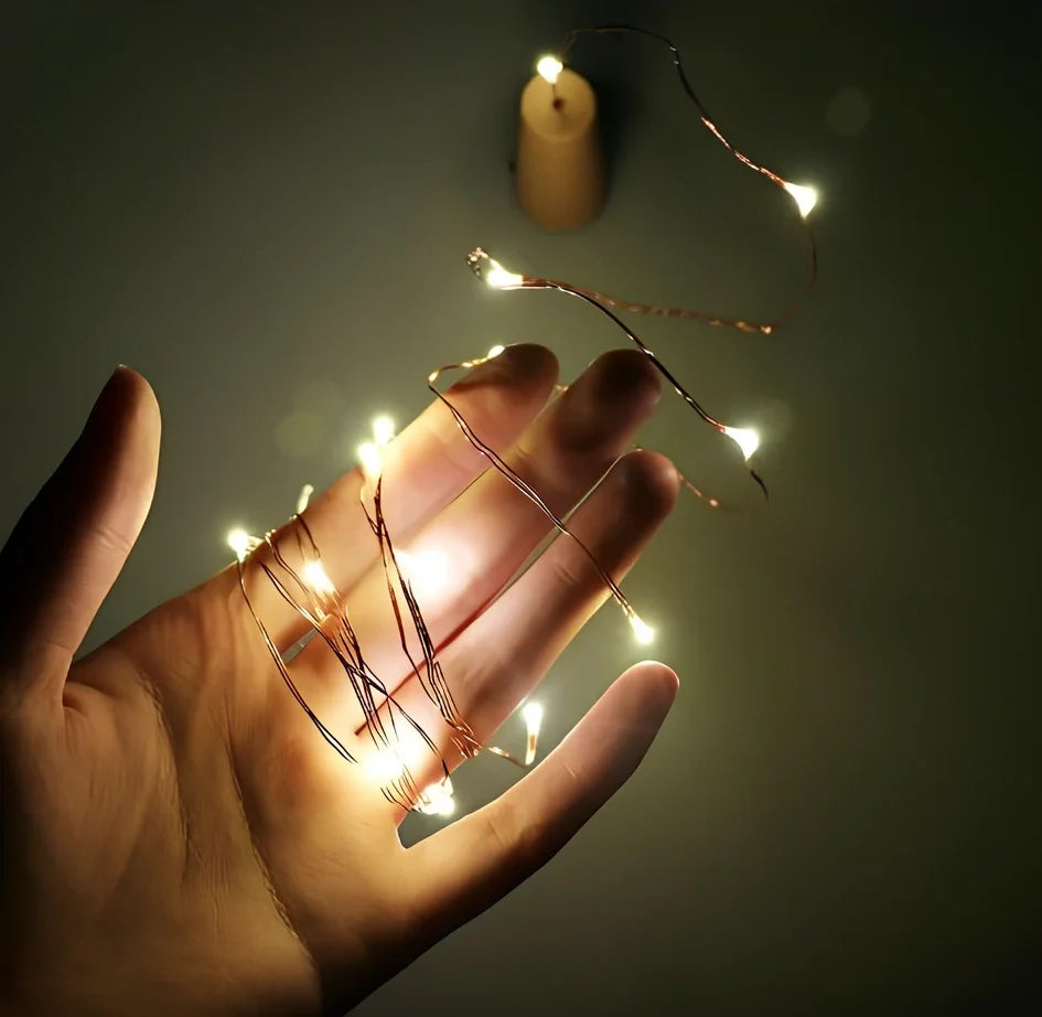 Copper wire LED string lights wrapped around wine bottle with 20 white LEDs illuminated