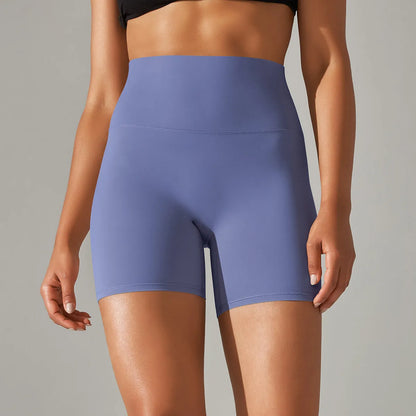 Woman wearing high waist hip lift fitness tights in a neutral colour, suitable for running or gym workout.