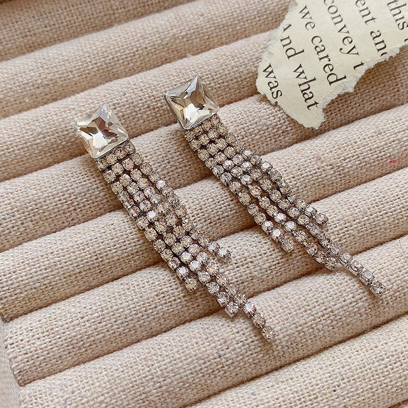 Sparkling zircon tassel earrings in sterling silver, featuring dazzling gems and flowing tassels for a bold, fashionable look.
