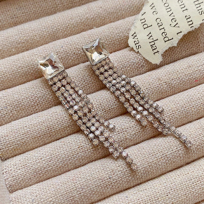 Sparkling zircon tassel earrings in sterling silver, featuring dazzling gems and flowing tassels for a bold, fashionable look.