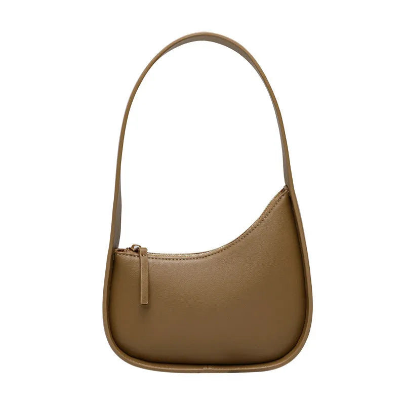 Structured caramel half-moon leather women's shoulder bag with a wide adjustable strap and zip closure.