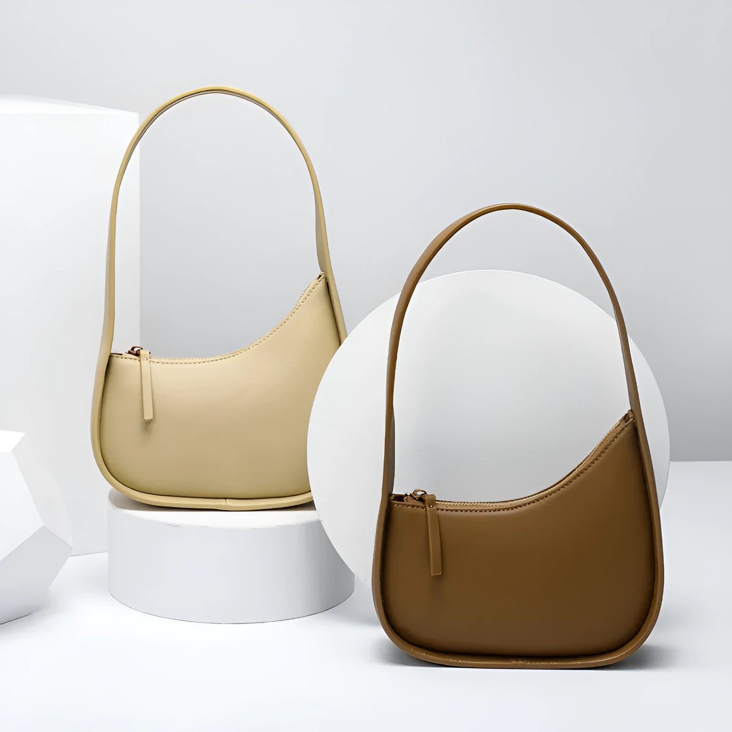 Structured caramel half-moon leather women's shoulder bag with a wide adjustable strap and zip closure.