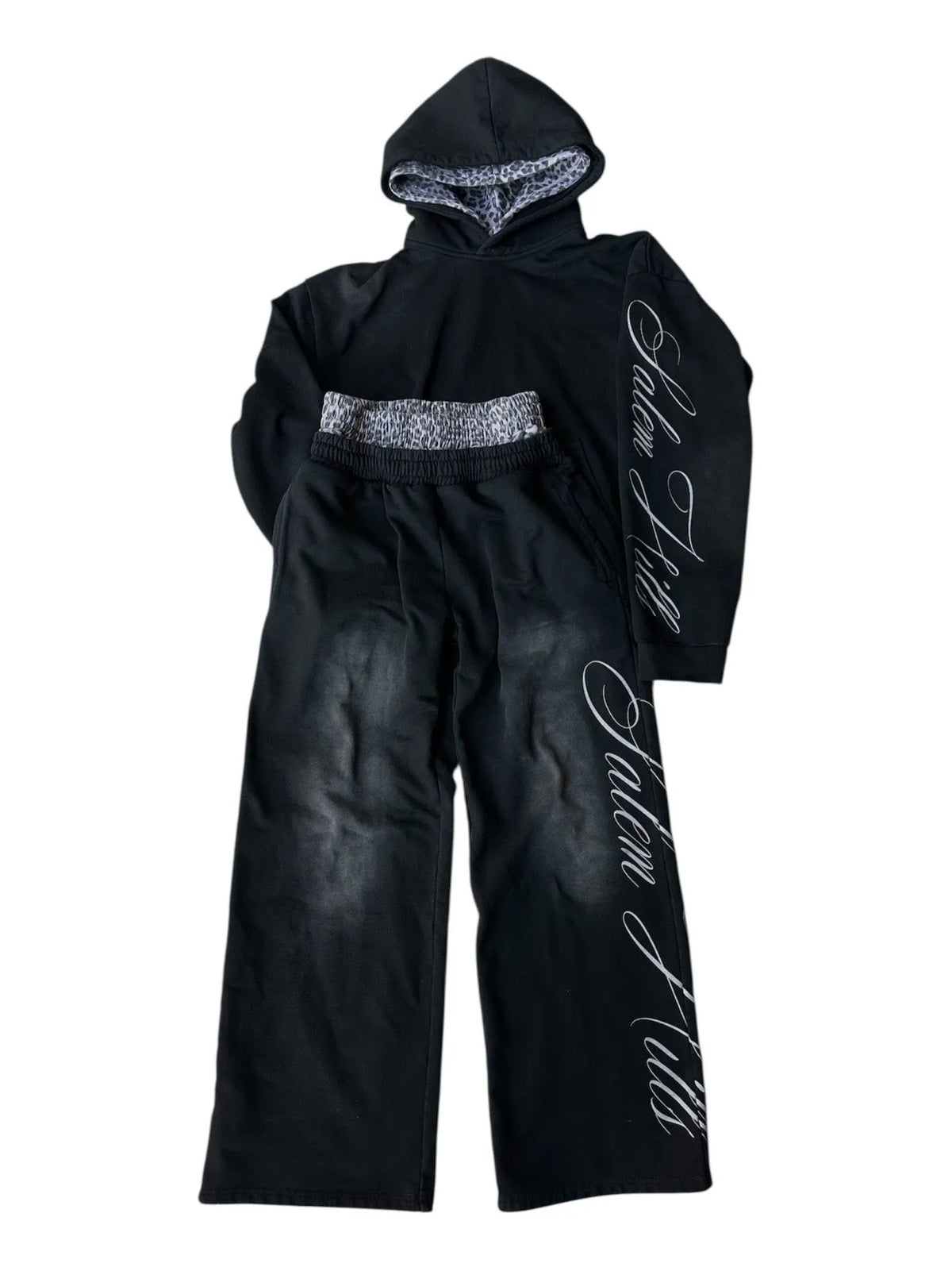 Man wearing a black punk print hoodie and matching trousers, a casual lounge suit set.
