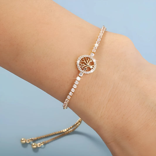 Close-up of a women's lucky tree design metal bracelet with zircon details on a wrist.