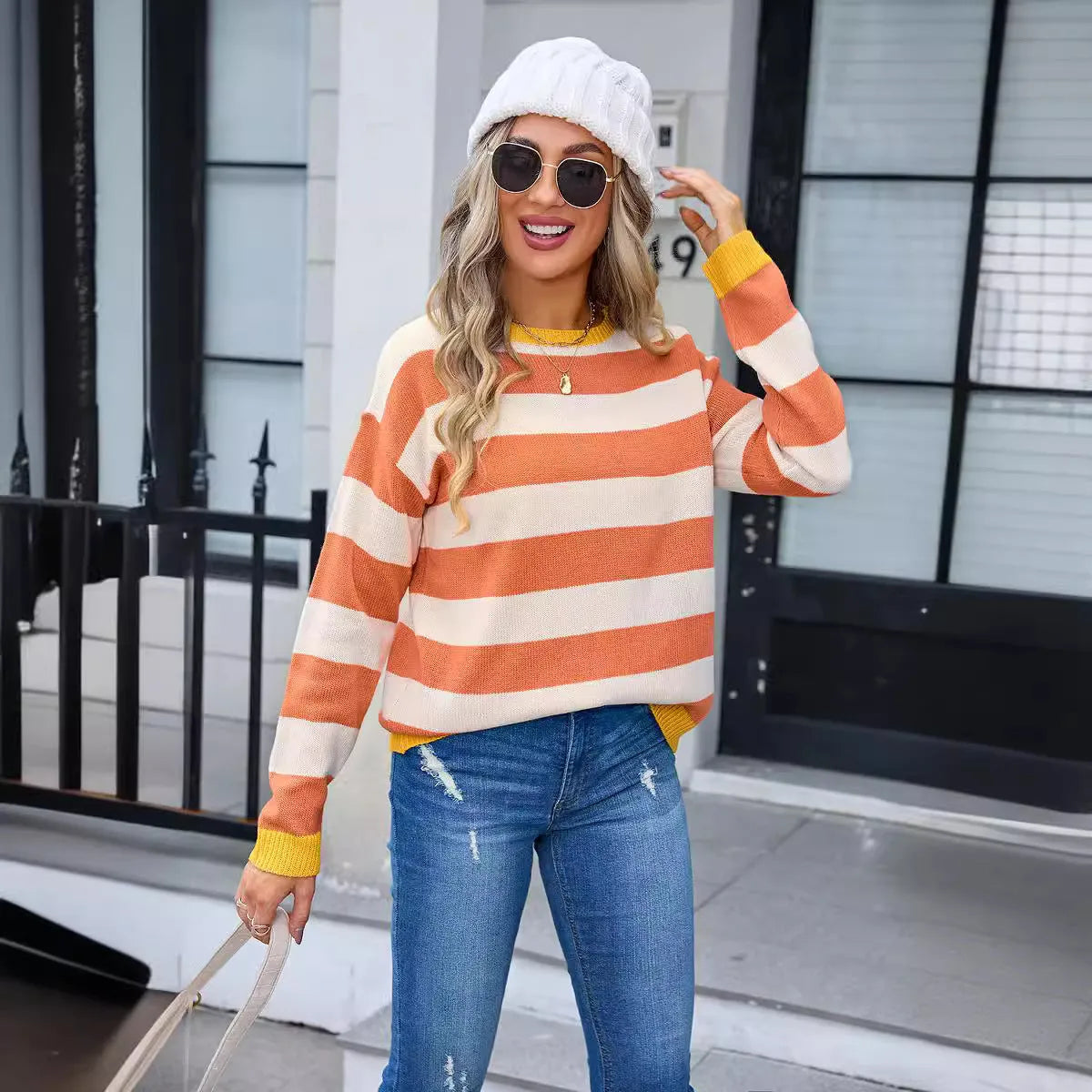Women's loose fit striped long sleeve round neck sweater on a hanger.