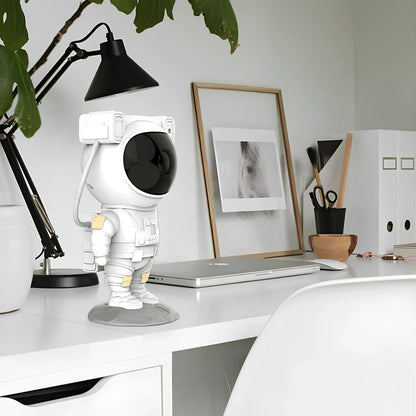 Astronaut-themed galaxy projector with adjustable nebula effects on table showing starry sky projection