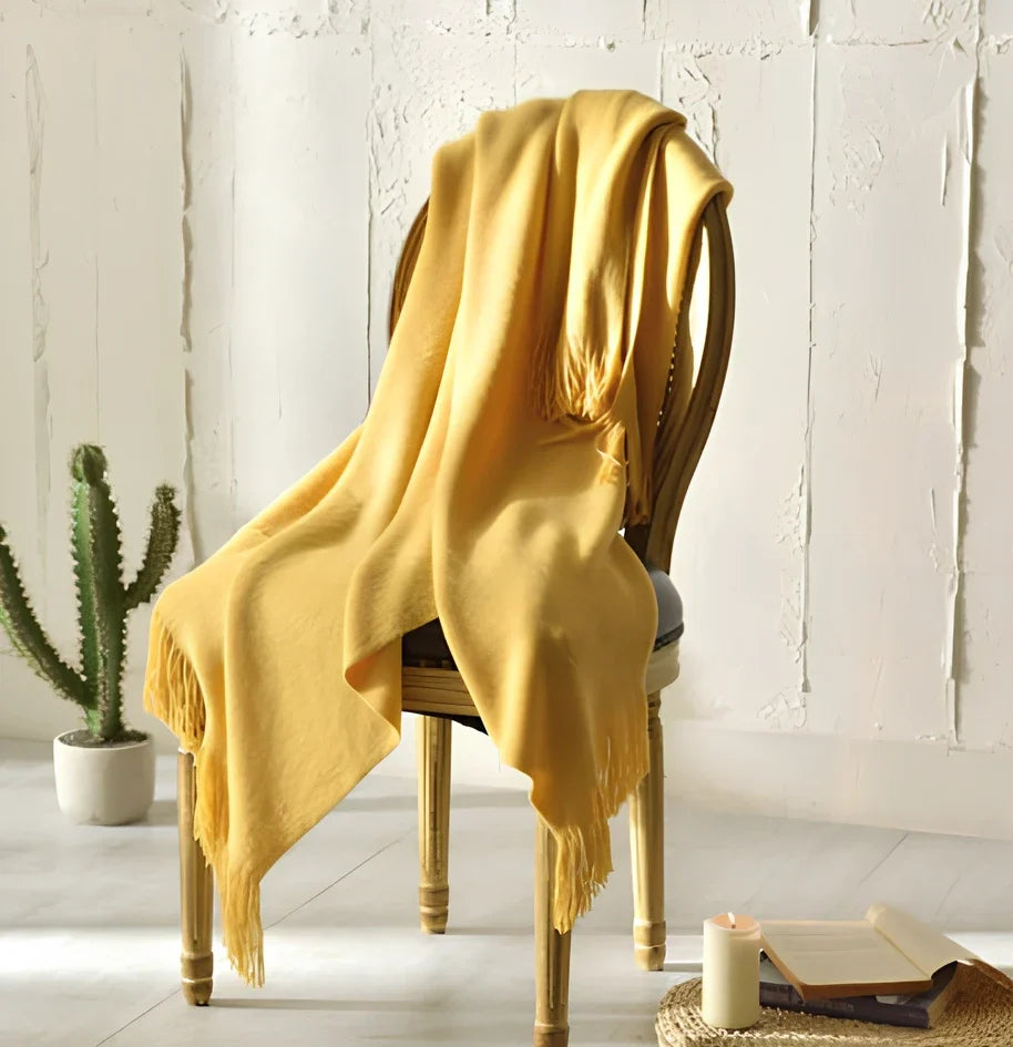 130x150cm knitted acrylic blanket with 10cm fringe detailing in beige colour draped over sofa