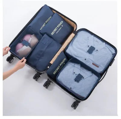 Set of six coloured nylon packing cubes and flat pouches for travel organisation.