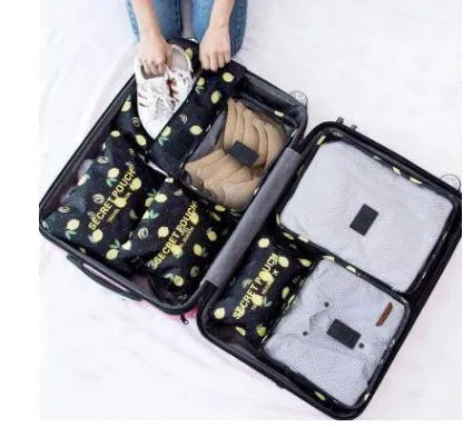 Set of six coloured nylon packing cubes and flat pouches for travel organisation.