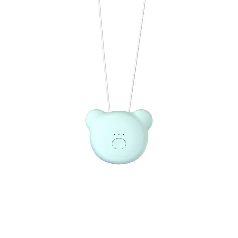 Pink wearable USB air purifier necklace on a table with USB cable, showing compact size.