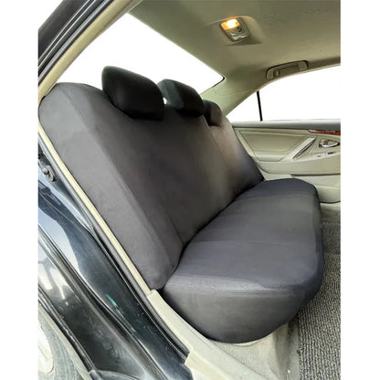 Polyester car seat cover set with eyelet stitching and sponge inserts in black, laid out on a car seat.