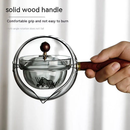 Glass teapot with wooden handle showing transparent borosilicate construction and removable infuser
