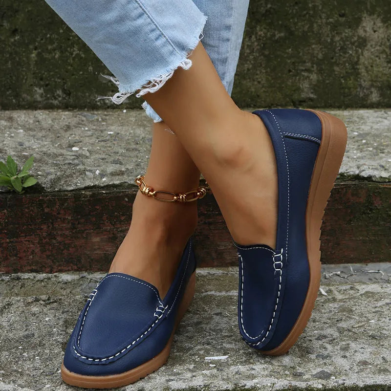 Women's flat shoes with car suture detailing on PU leather upper, round toe, rubber sole, available in multiple colours