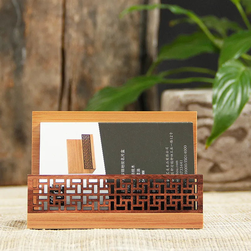 Geometric bamboo and black walnut wood business card holder on a desk.