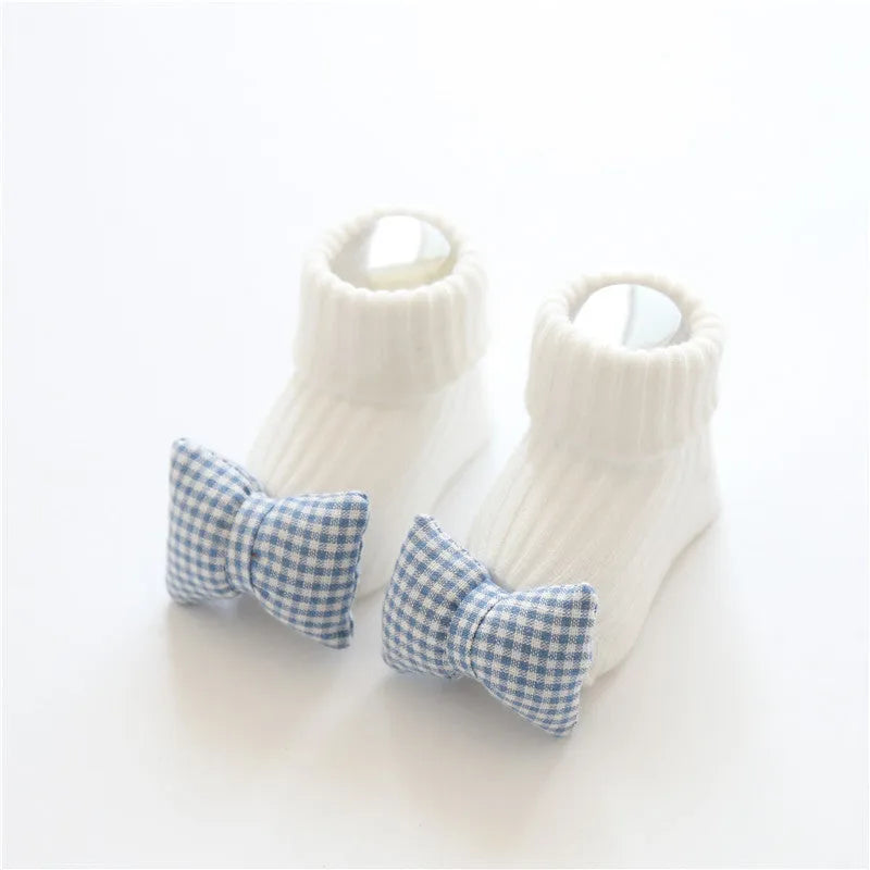 Cotton baby floor socks in assorted colours and patterns including bows, stars, and animal designs.